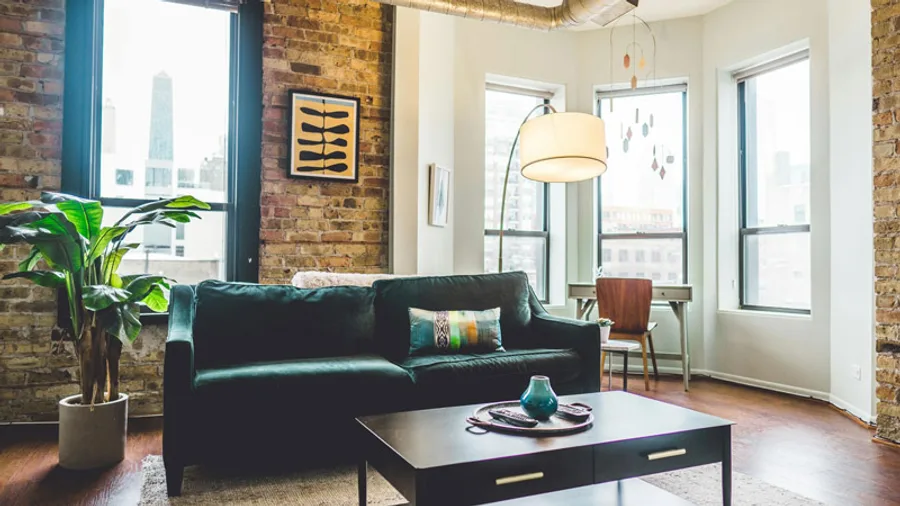 Remodeled living room with exposed brick and a green velvet sofa