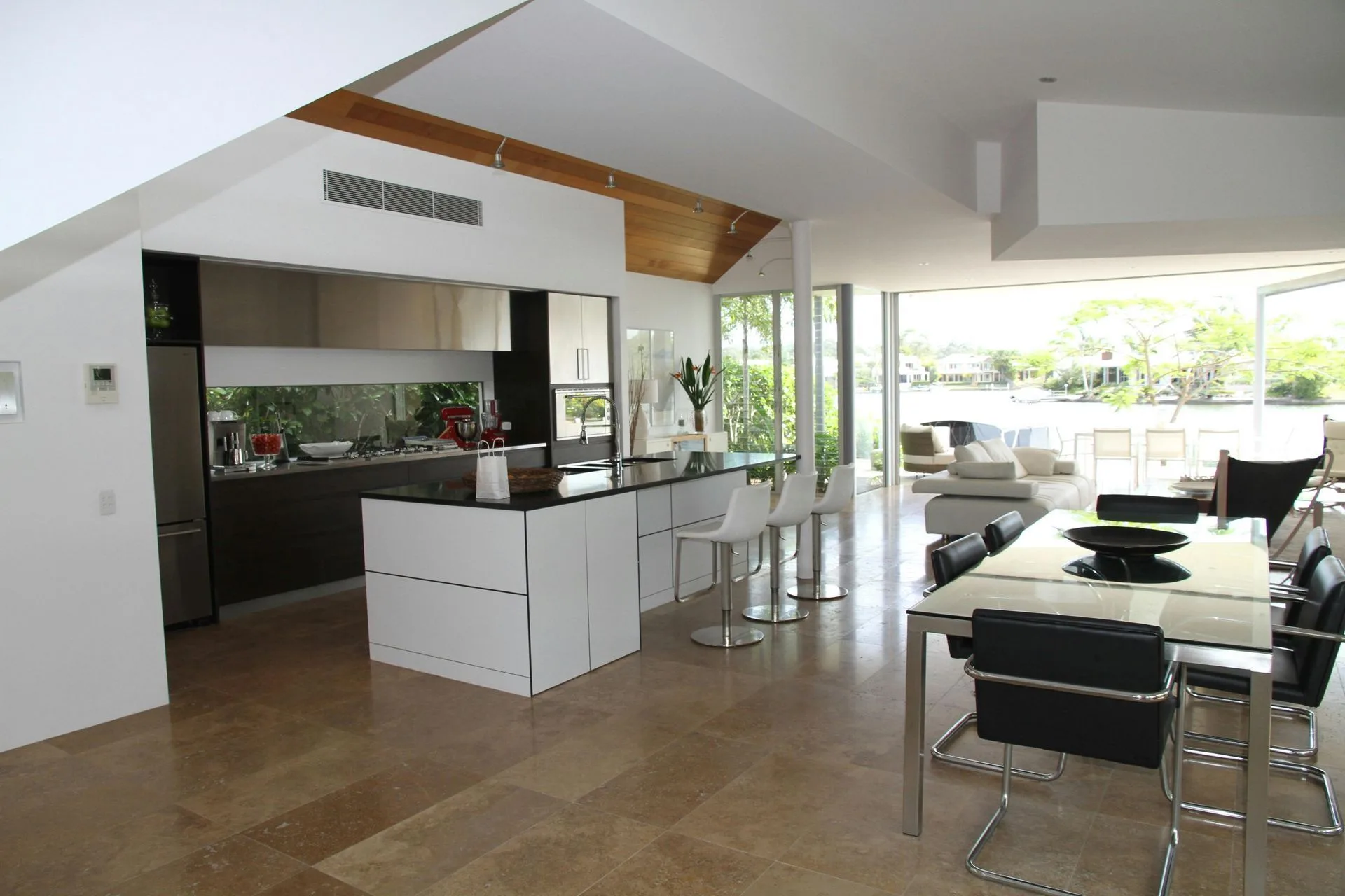Open-plan kitchen and dining space with a handleless island and garden view