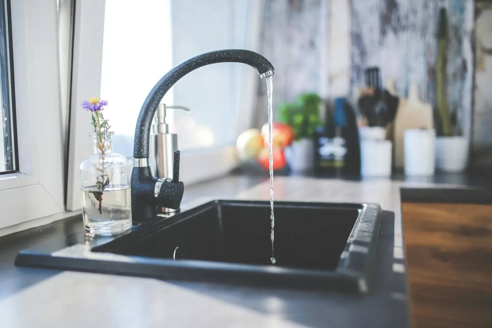 Black granite undermount sink with a gooseneck faucet