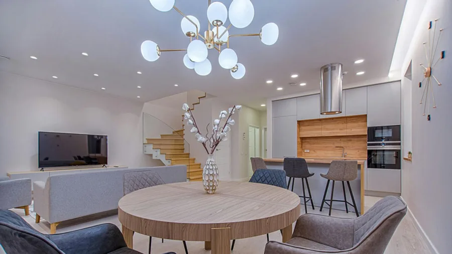 Open-plan kitchen and dining area lit by a large globe chandelier